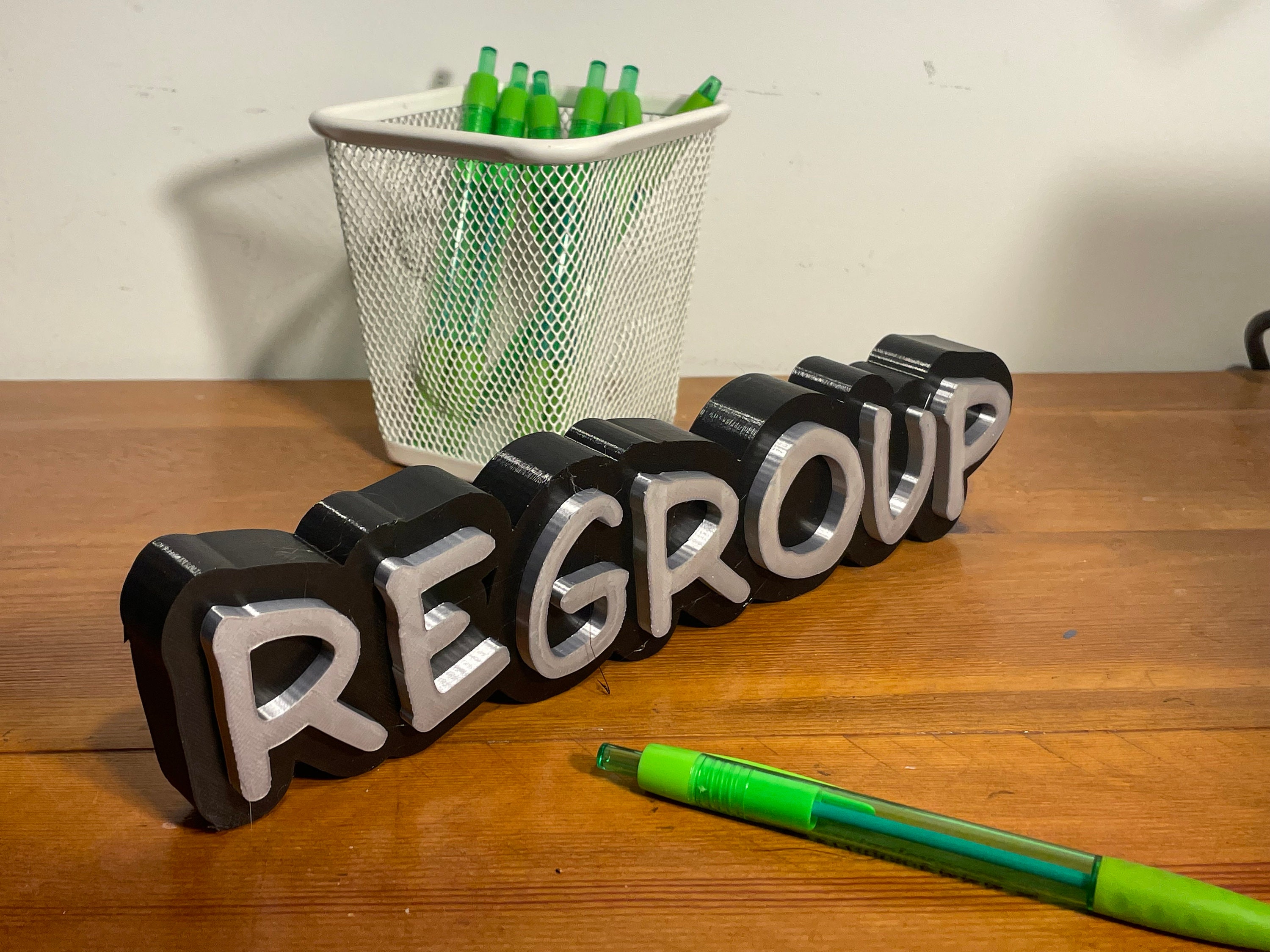 Ein 3D-gedrucktes Schild mit einem motivierenden Zitat an einer Bürowand.