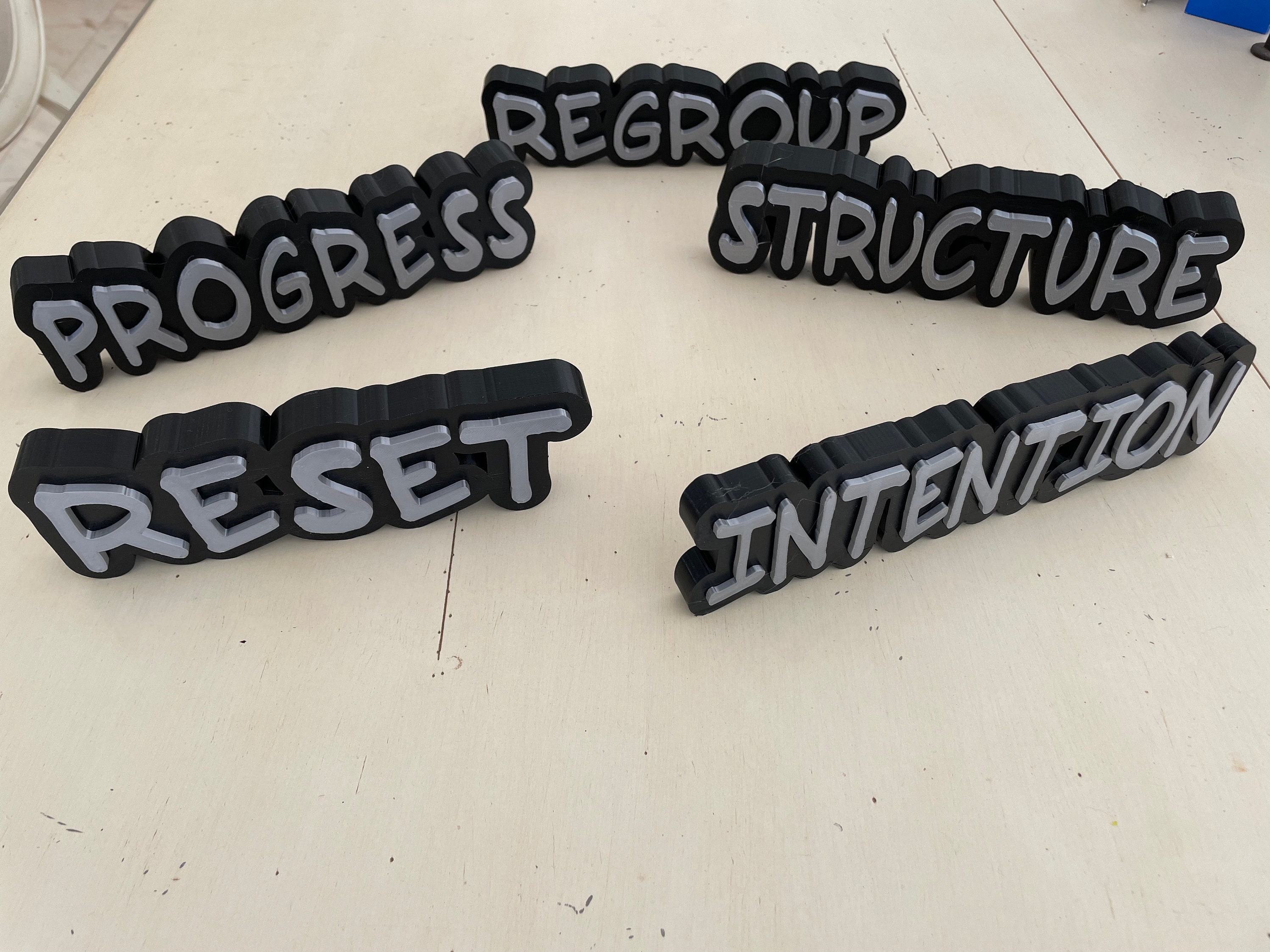 Eine Sammlung einzigartiger, 3D-gedruckter, individueller Geschäftsschilder für das Büro-Branding.